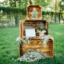 Rustic wedding outdoor photo zone. Hand made wedding decorations includes wooden boxes, flowers and plate Love Is In The Air.